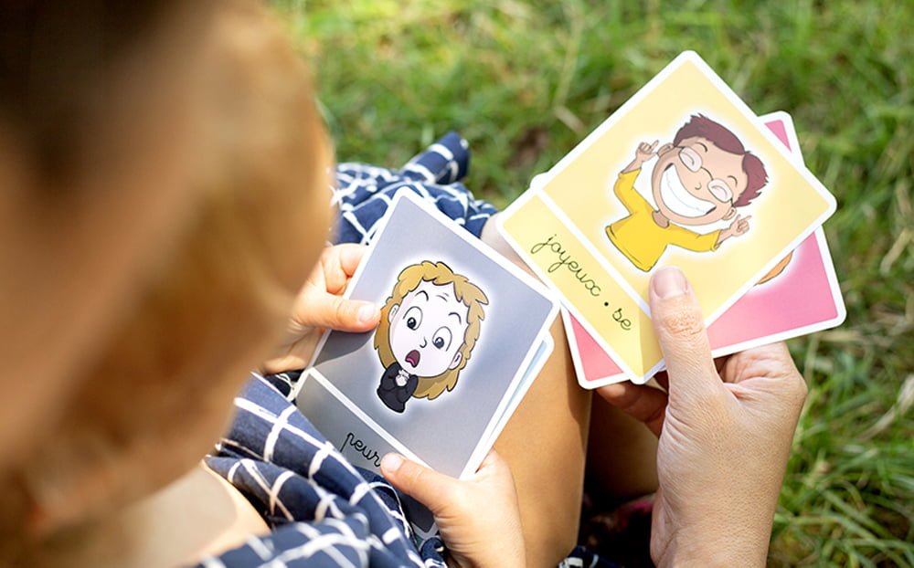 Enfant et adulte jouant avec les cartes des émotions bougribouillons